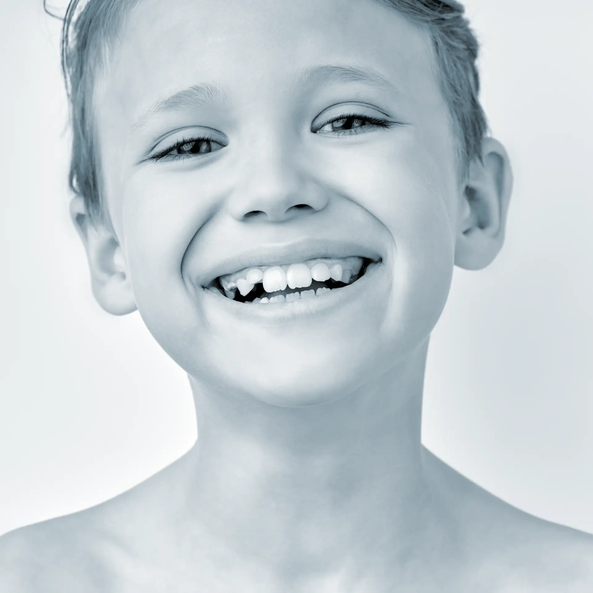 Lachendes Kind mit weißen Zähnen und Zahnlücke